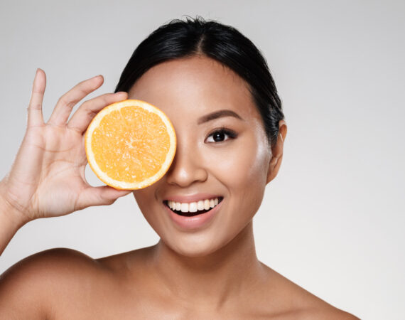 woman holding orange slices near her face